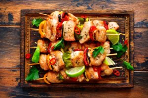 Grilled,chicken,kebab,(skewers),with,vegetables,on,a,cutting,wooden