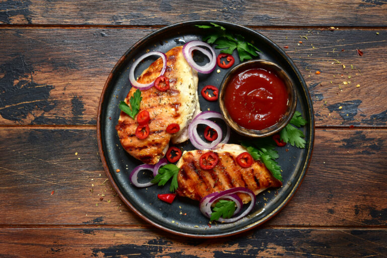 Grilled,spicy,chicken,breasts,with,ketchup,on,a,rustic,wooden